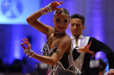 Dancesport competitor: Female dancer: black Latin dress with silver sequins and crystals, featuring a d