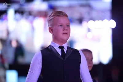 Dancesport competitor: Male dancer: white long-sleeved shirt, black tie, and a dark waistcoat