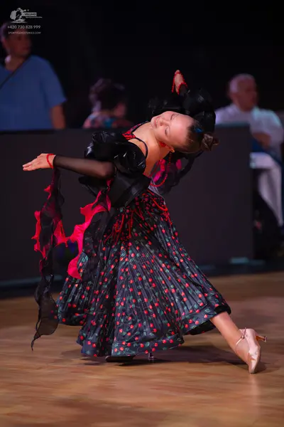 Dancesport competitor: Female dancer: black and red latin dress with a patterned pleated skirt and blac