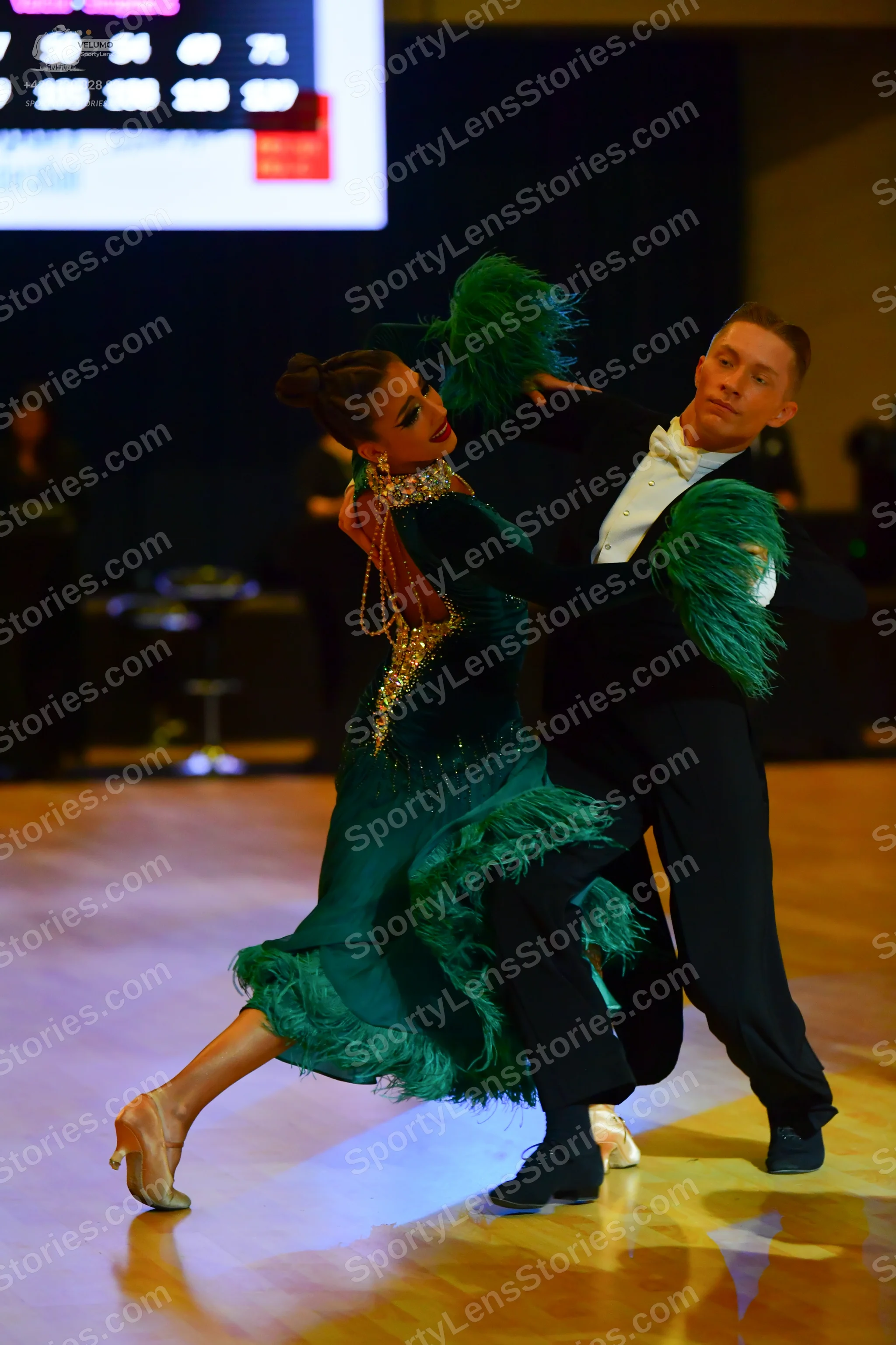 Dancesport competitor: Female dancer: emerald green long-sleeved dance dress with gold and silver sequi