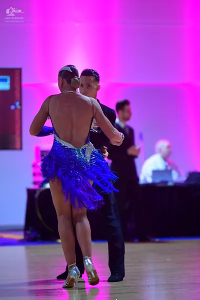 Dancesport competitor: Female dancer: blue Latin dance dress with fringe and sequins, backless style, w