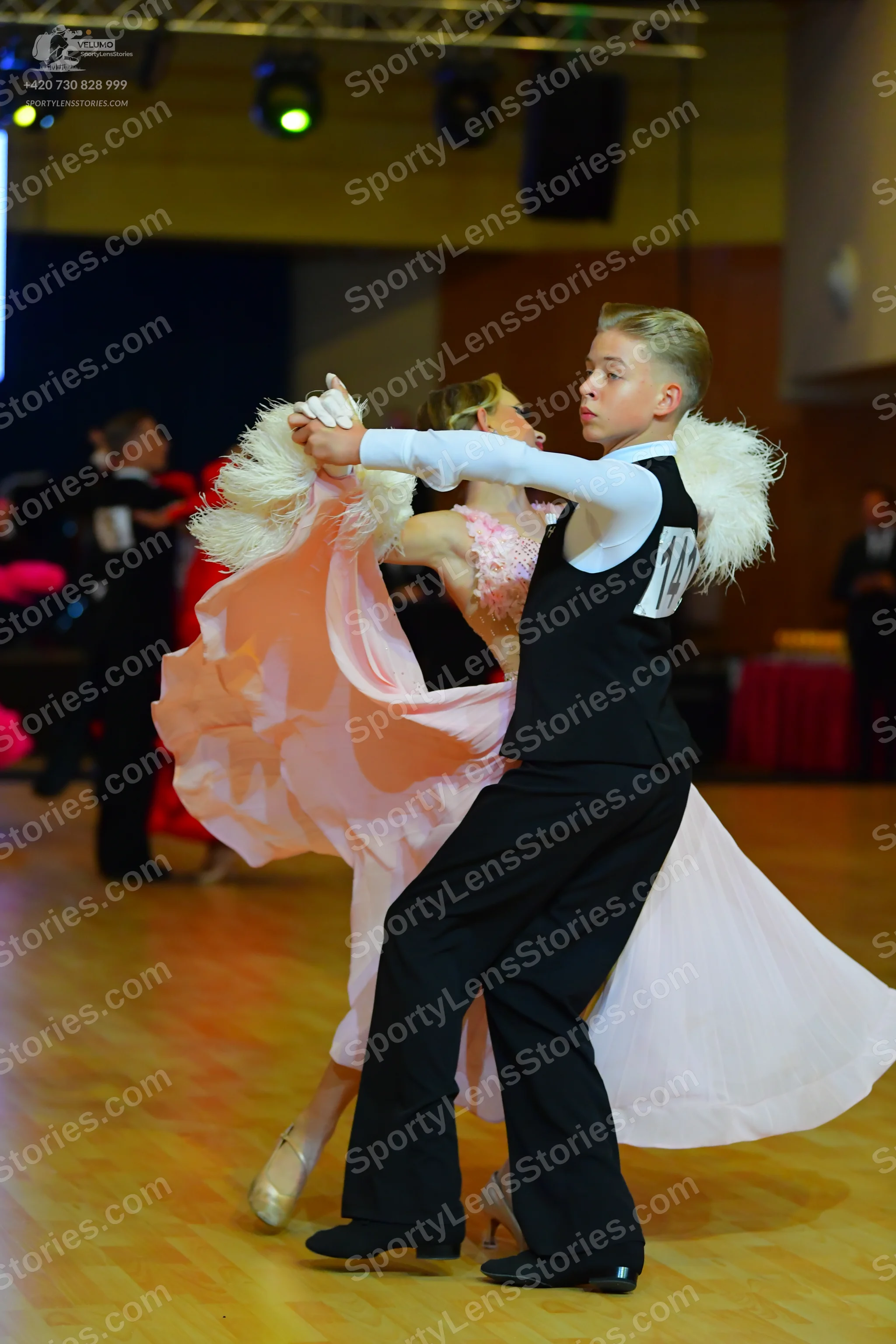 Dancesport competitor #14: Male dancer: black waistcoat, white long-sleeved shirt with large white feather 