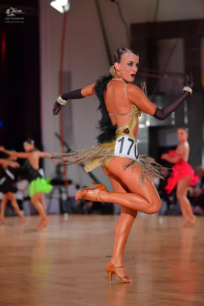 Dancesport competitor #170: Main dancer: gold sequin latin dress with a fringe skirt and long black gloves