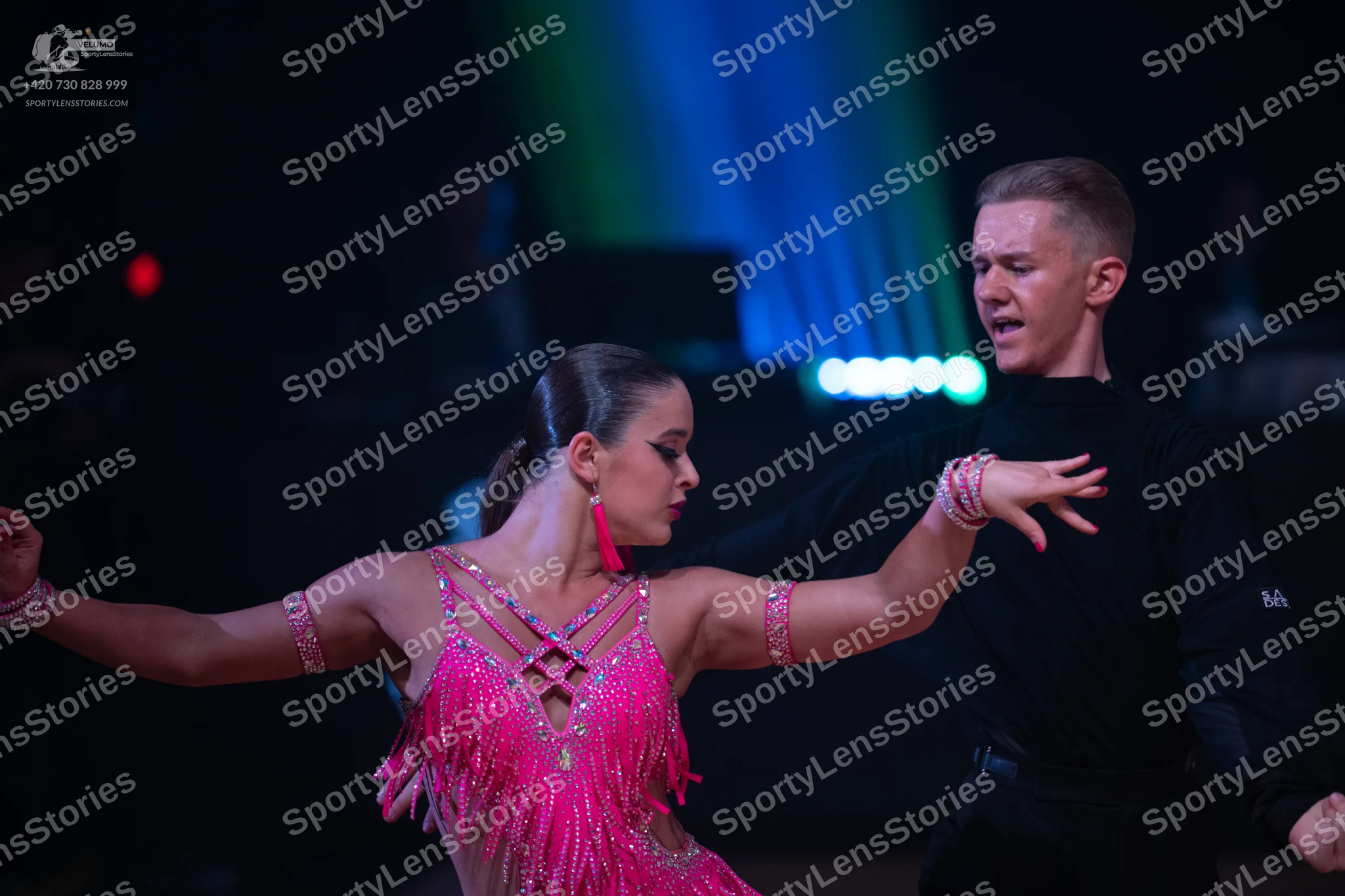 Dancesport competitor: Female dancer: pink latin dress with sequins and fringe, and matching armbands
