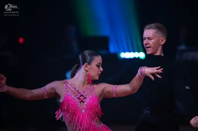 Dancesport competitor: Female dancer: pink latin dress with sequins and fringe, and matching armbands