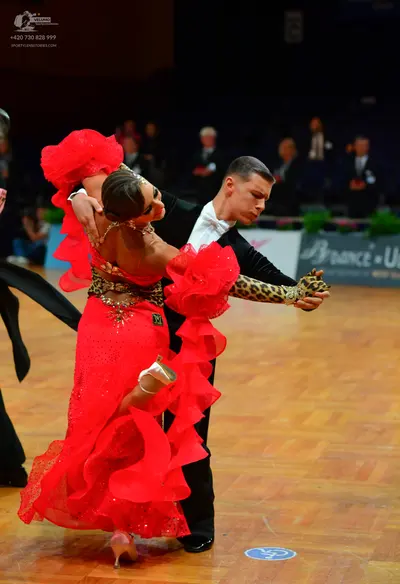 Dancesport competitor: Female dancer: red Latin dress with large, voluminous ruffles and a leopard-prin
