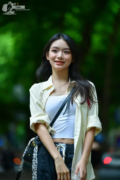 Dancesport competitor: The person is wearing a cream-colored long-sleeved button-up shirt worn open ove