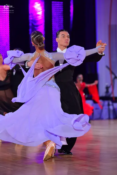 Dancesport competitor: Main female dancer: light purple ballroom gown with a voluminous ruffled skirt a