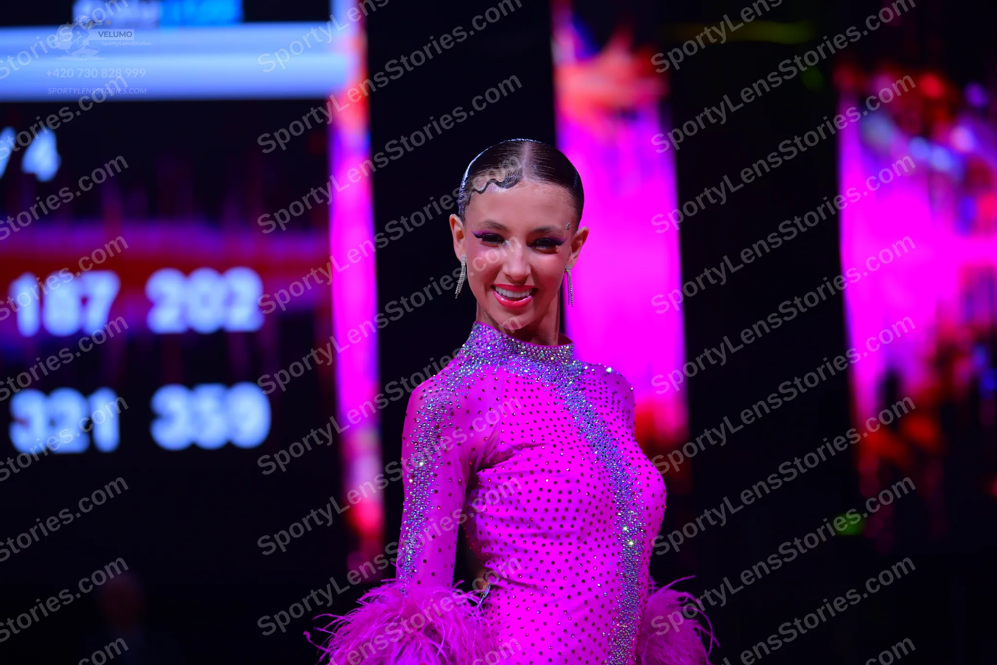 Dancesport competitor: Female dancer: bright pink latin dance dress with sequins and pink feathery trim