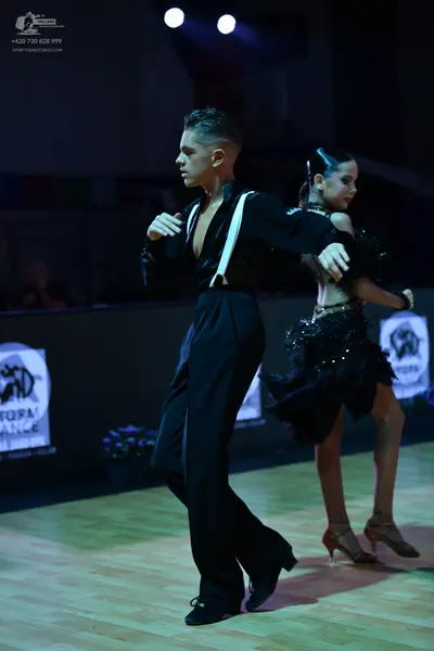 Dancesport competitor: Male dancer: black long-sleeved shirt with white suspenders and black trousers