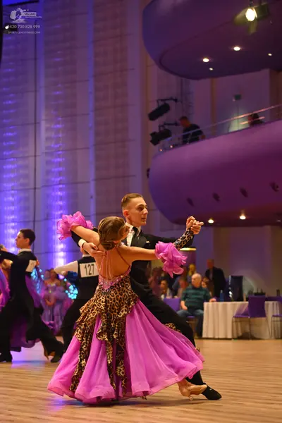 Dancesport competitor: Female dancer: pink latin dress with leopard print pattern and a sheer, flowing 