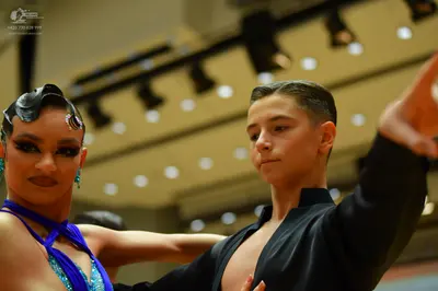 Dancesport competitor: Female dancer: blue sequined latin dance top with straps and blue earrings