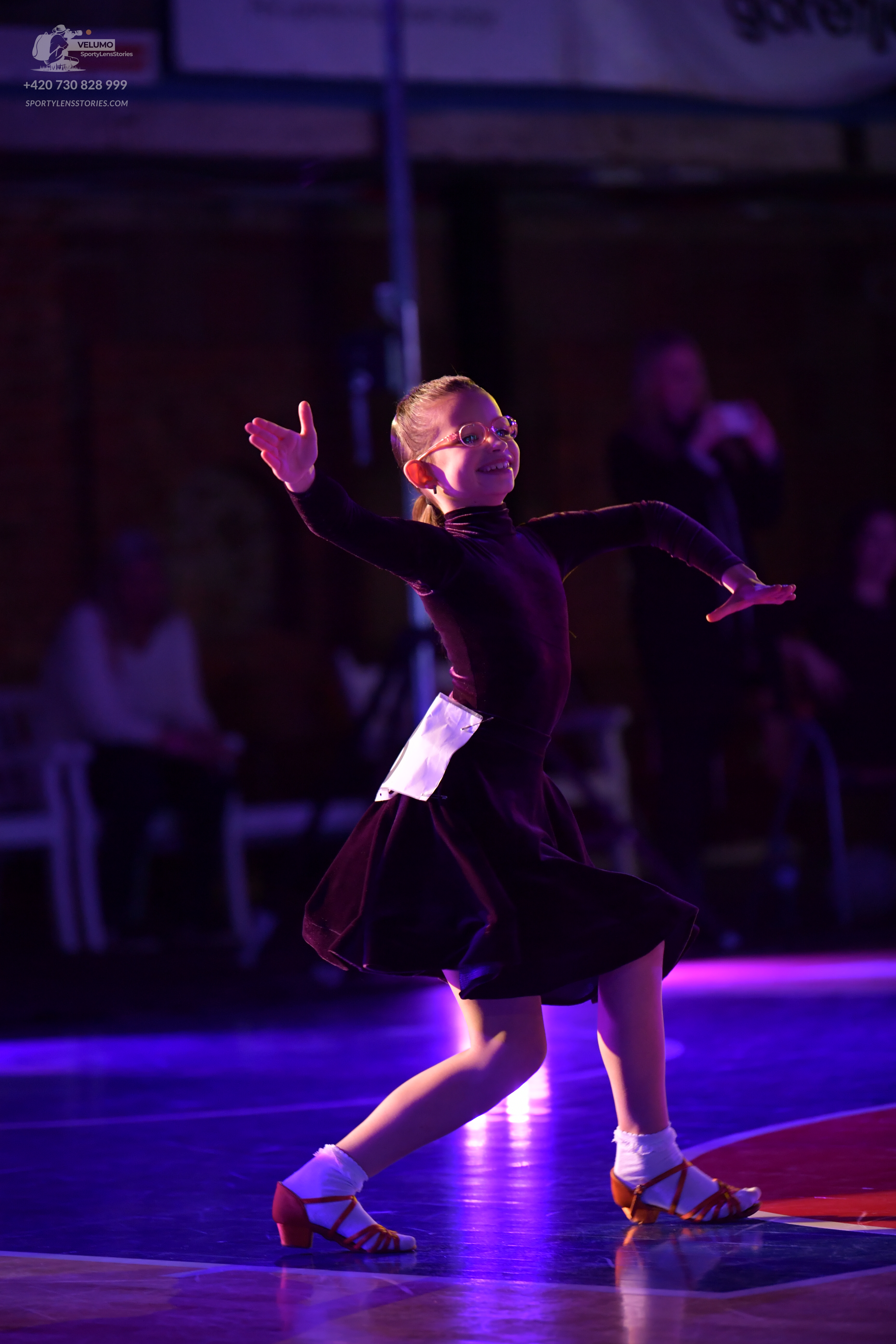 Dancesport competitor: Female dancer: dark, long-sleeved dress with a flared skirt