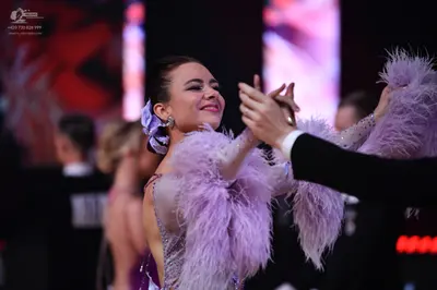 Dancesport competitor: Female dancer: light purple/lavender latin dress with sequins and large feather 