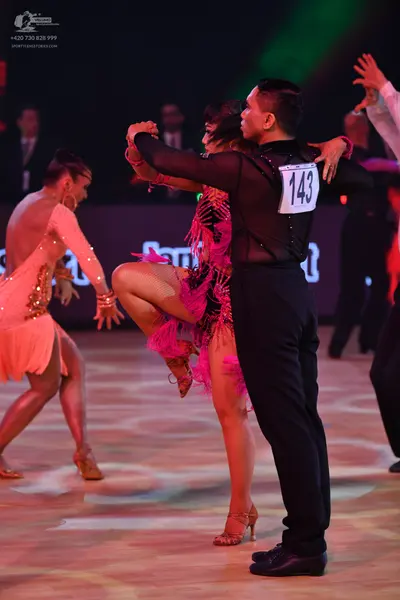 Dancesport competitor: Male dancer: black long-sleeve shirt with sheer fabric and black trousers