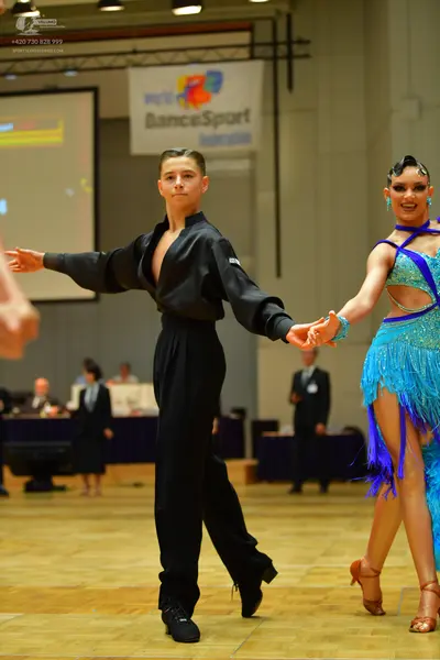 Dancesport competitor: Male dancer: black long-sleeved shirt with puffed sleeves and black trousers