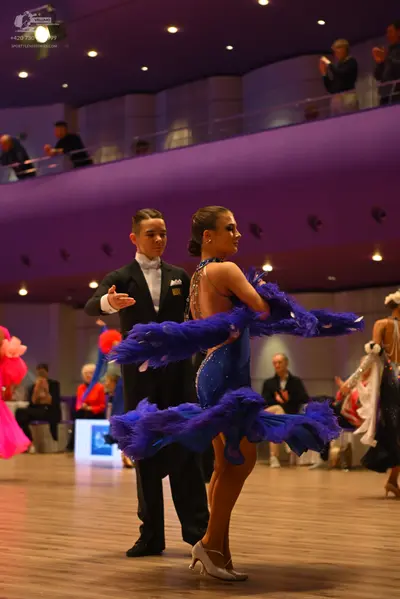 Dancesport competitor: Male dancer: black suit with a white shirt, white bowtie, and a white pocket squ