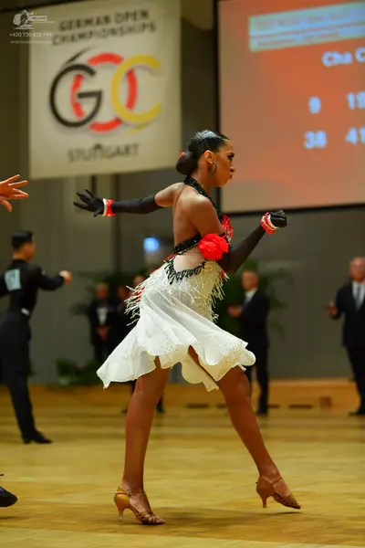 Dancesport competitor: Female dancer: white latin dress with lace/mesh detail and red floral/fabric acc