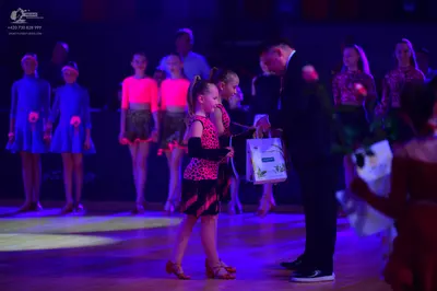 Dancesport competitor: Female dancers: light blue long-sleeved dresses, magenta long-sleeved tops with 