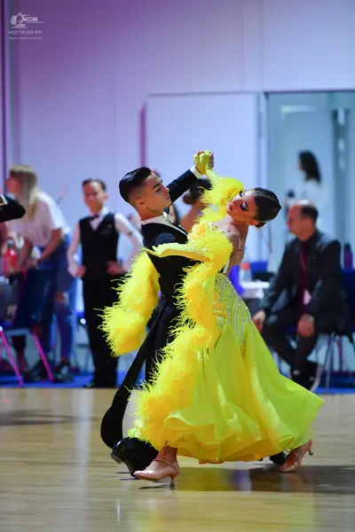 Dancesport competitor: Male dancer: black long-sleeved ballroom top with white trim and black trousers