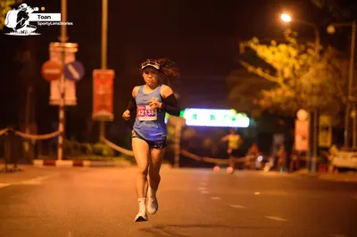 Marathon runner #42138: Runner 1: blue tank top, black shorts, white shoes, white headband, and black ar