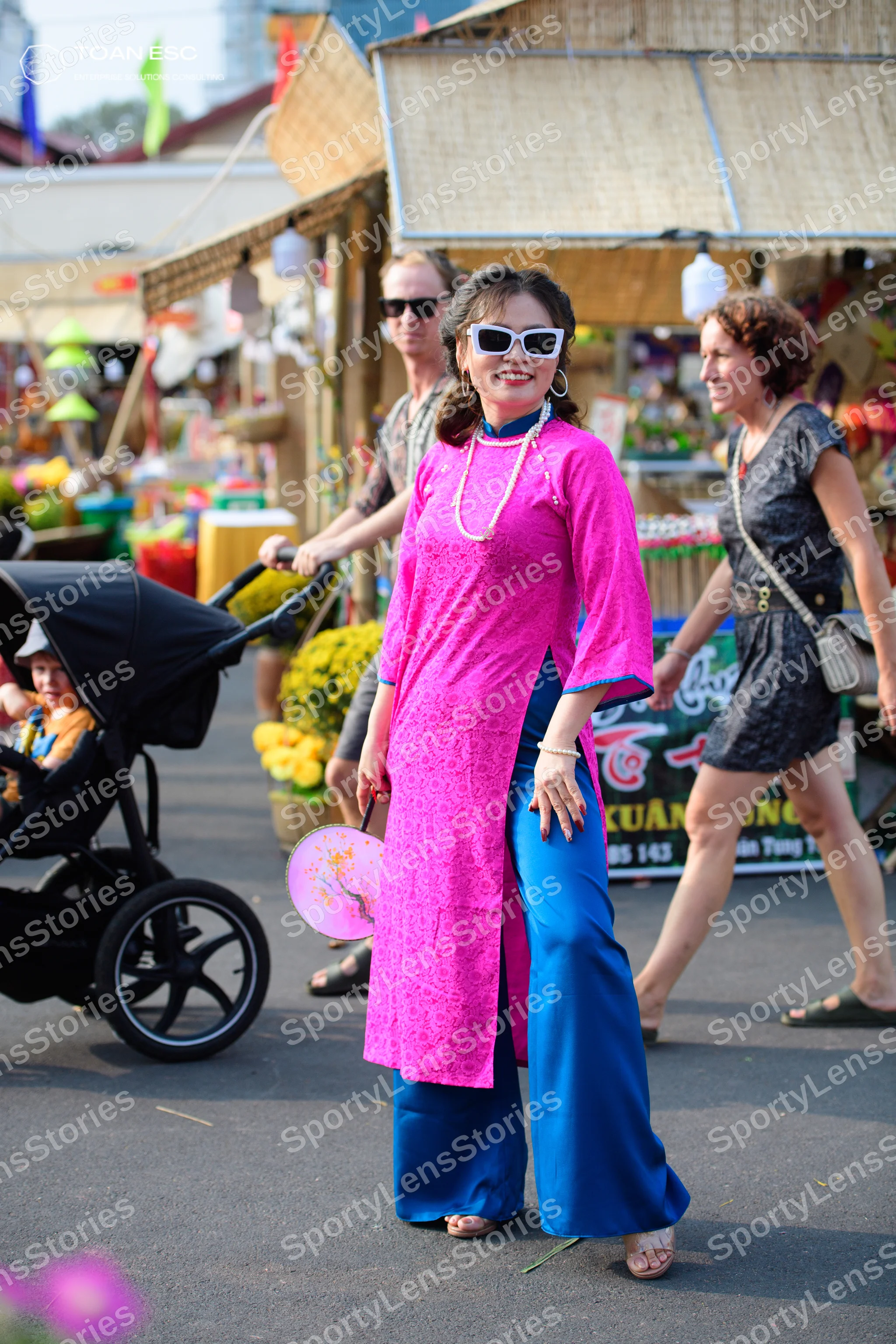Dancesport competitor: Female dancer: pink patterned long-sleeve tunic with blue wide-leg trousers, pea