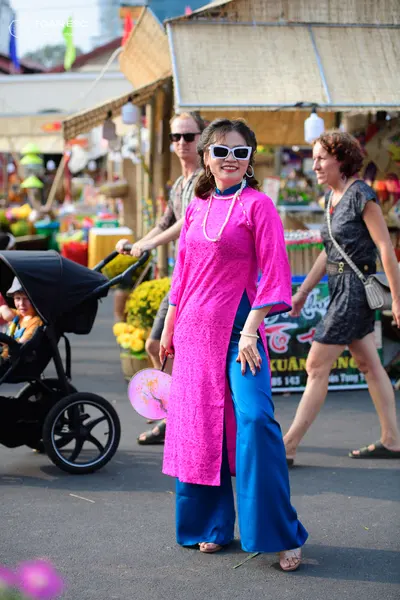 Dancesport competitor: Female dancer: pink patterned long-sleeve tunic with blue wide-leg trousers, pea