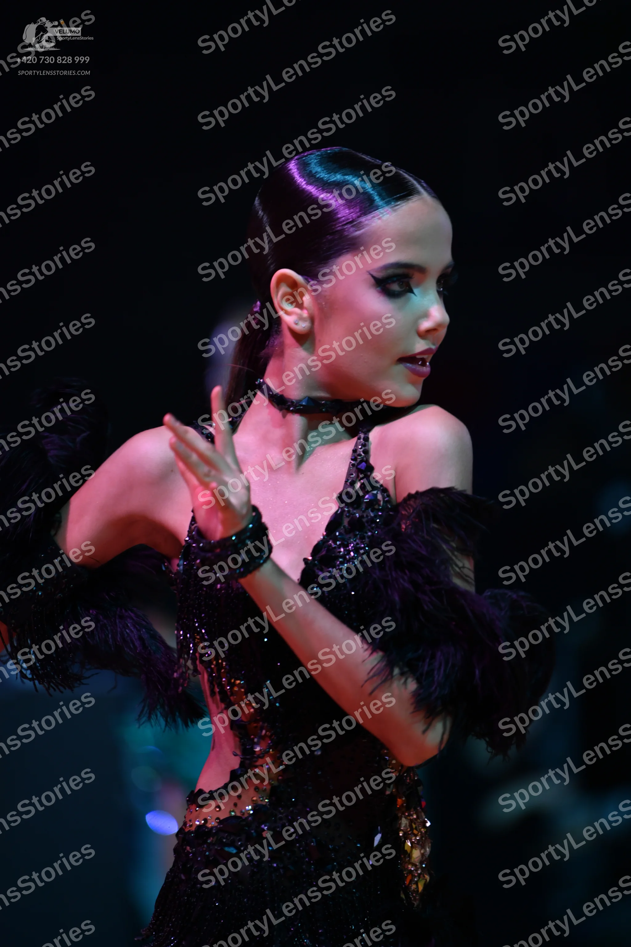 Dancesport competitor: Female dancer: black latin dress with black sequins and large black feather-like