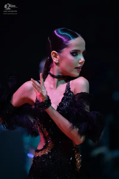 Dancesport competitor: Female dancer: black latin dress with black sequins and large black feather-like