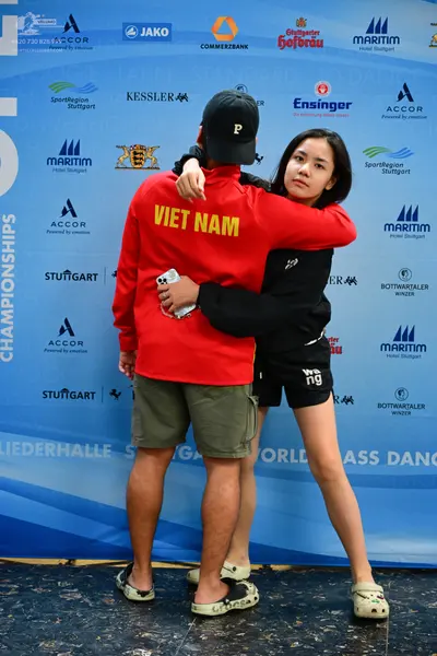 Dancesport competitor: Male dancer: red long-sleeved sweatshirt with "VIET NAM" in yellow on the back, 