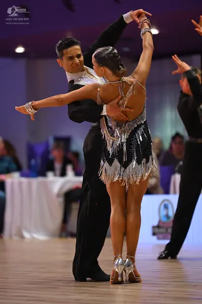 Dancesport competitor: Male dancer: black suit with a white shirt featuring sequin detailing at the col