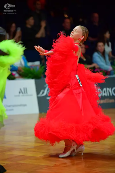 Dancesport competitor: Female dancer: red latin dress with large red feathers