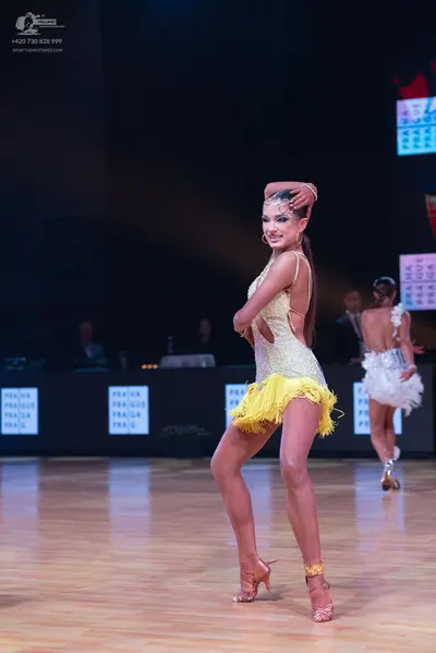 Dancesport competitor: Female dancer 1: champagne-colored sequined Latin dress with a bright yellow fri