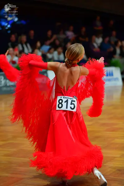 Dancesport competitor #815: Female dancer: red latin dress with large feather-like fringe on the sleeves and