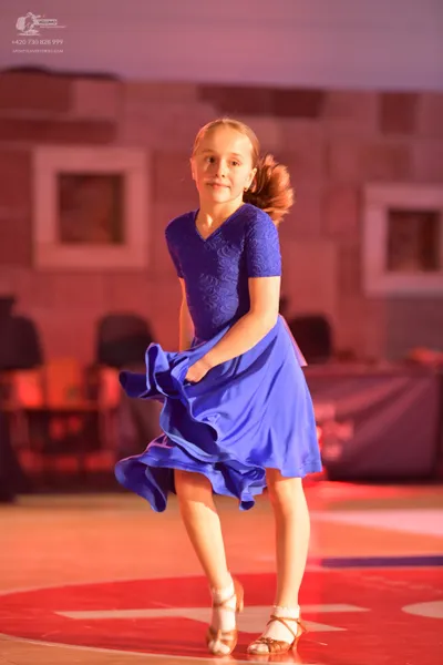 Dancesport competitor: Female dancer: royal blue latin dress with a lace bodice and a flowing satin ski