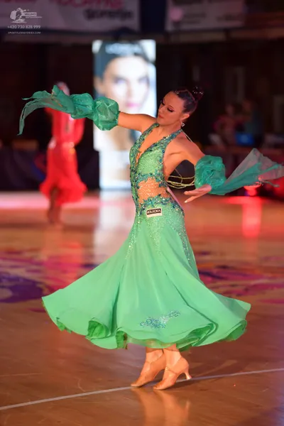 Dancesport competitor: Female dancer in foreground: mint green ballroom dress with a voluminous flowing