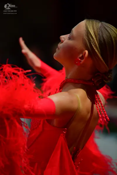 Dancesport competitor: Female dancer: red latin dress with red feathers and red sleeves