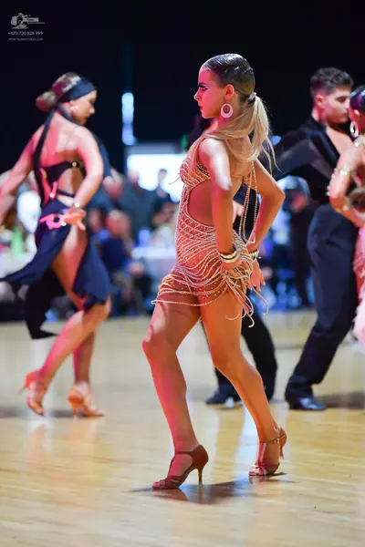 Dancesport competitor: Female dancer 1: dark blue or black Latin dress with thin straps and cutouts