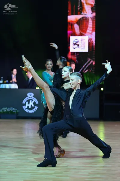 Dancesport competitor: Male dancer: black long-sleeved shirt with a deep V-neck and black trousers