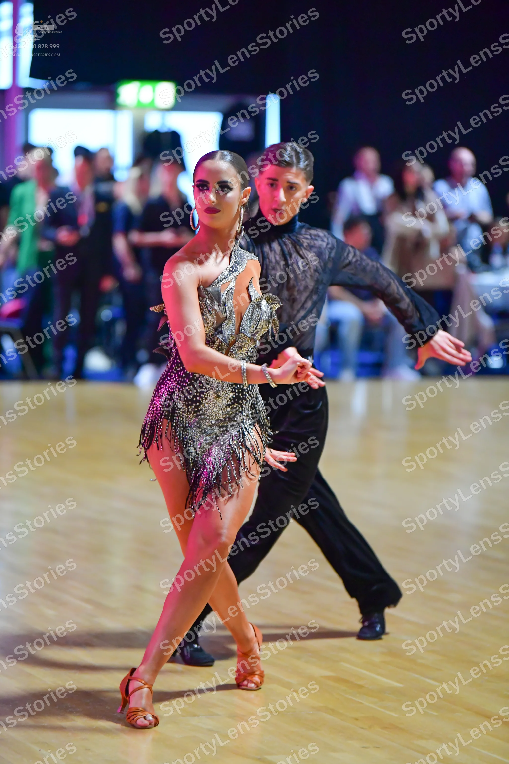 Dancesport competitor: Female dancer: metallic gold one-shoulder Latin dress with sequins and fringe, h
