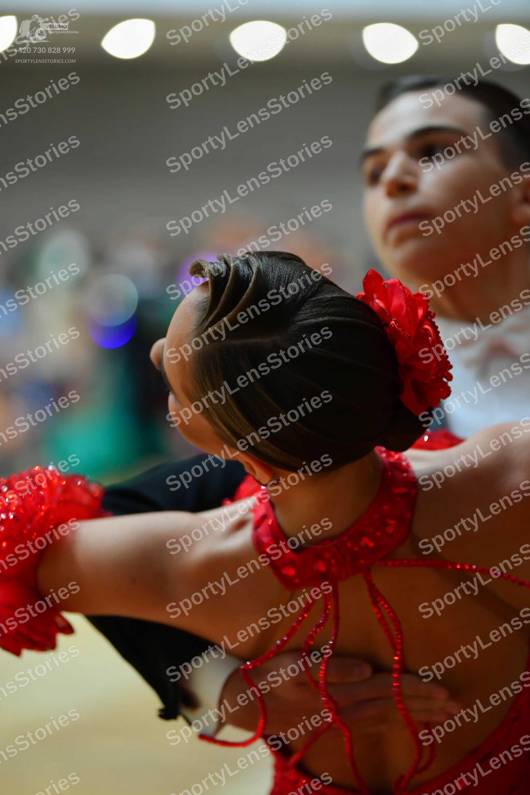 Dancesport competitor: Female dancer: red sequined latin dress with a red flower in her hair