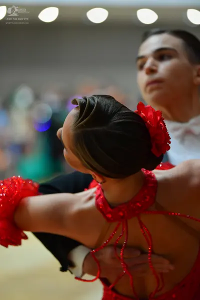 Dancesport competitor: Female dancer: red sequined latin dress with a red flower in her hair