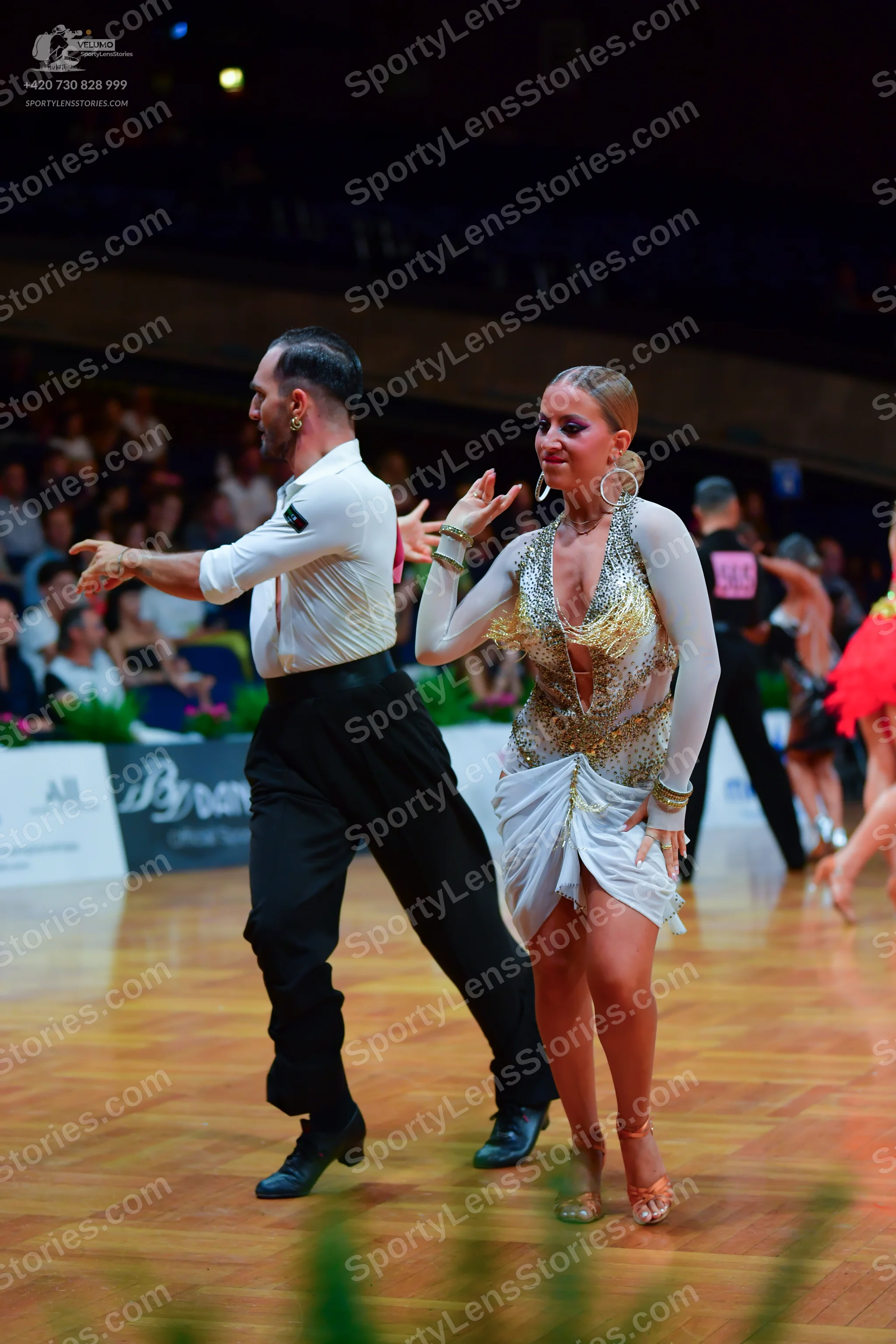 Dancesport competitor: Male dancer (foreground): white long-sleeved shirt, black trousers, and black da