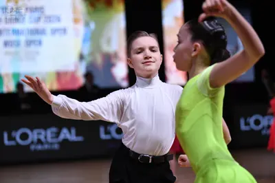Dancesport competitor: Male dancer: white long-sleeved high-neck shirt and black trousers with a black 