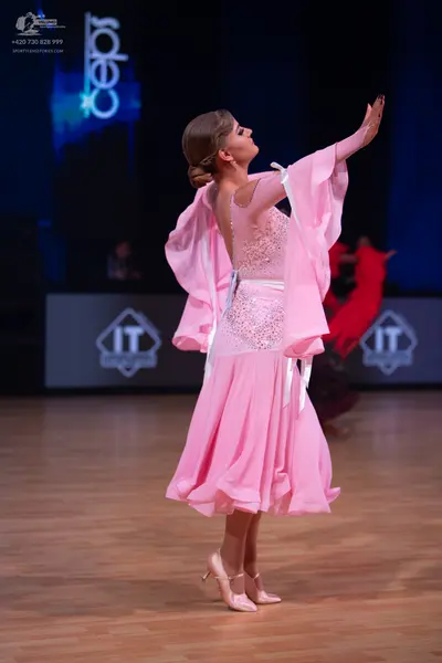 Dancesport competitor: Female dancer: pink ballroom dress with a shimmering, embellished bodice and flo