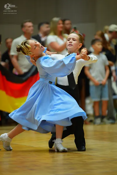 Dancesport competitor: Female dancer: light blue satin-like ballgown with long voluminous sleeves and a