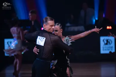 Dancesport competitor: Male dancer: black, long-sleeved, semi-sheer shirt and black trousers