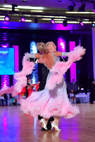 Dancesport competitor: Female dancer: light blue/silver sequined ballroom dress with a large, voluminou