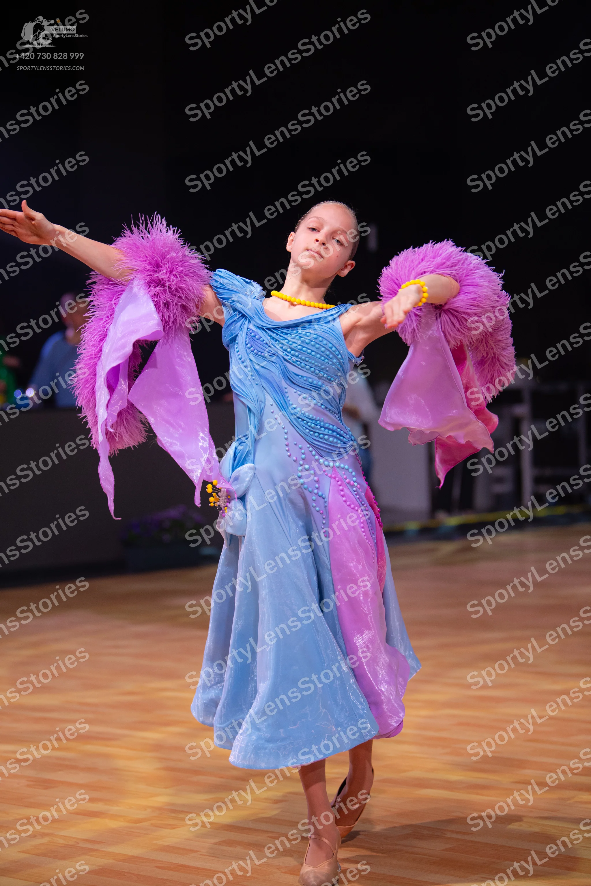 Dancesport competitor: Female dancer: light blue and pink Latin dress with voluminous, feathery/ruffled