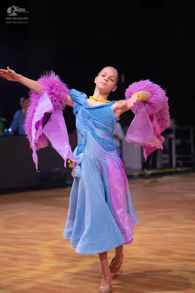 Dancesport competitor: Female dancer: light blue and pink Latin dress with voluminous, feathery/ruffled
